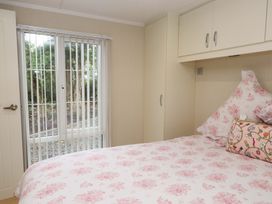 A bedroom with a bed and wardrobe at The Chalet at Tyn Lon Chwilog
