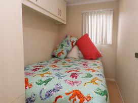 A bedroom with a bed covered in a colorful blanket at The Chalet at Tyn Lon Chwilog