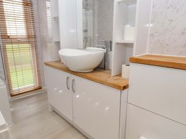 A bathroom with a sink and cabinet at The Chalet at Tyn Lon in Chwilog