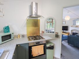 A kitchen with a gas stove and microwave at Charnwood 