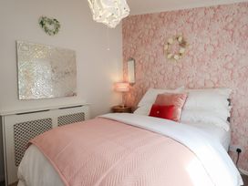 A bedroom with a bed, lamp, and mirror at Charnwood