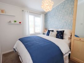 A bedroom with a bed and shelves at Charnwood