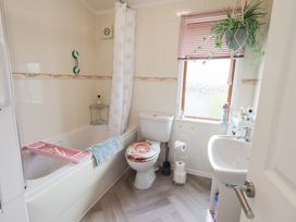 A bathroom with a bathtub and sink at Charnwood