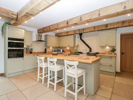 A kitchen with an island and chairs at Two Parks Barn Upton Bishop near Ross-On-Wye