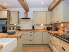 A kitchen with cabinets, a sink, and an oven at Two Parks Barn in Upton Bishop near Ross-On-Wye