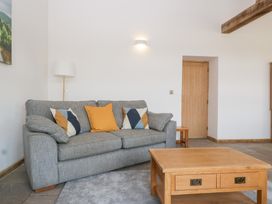 A living room with a sofa and a wooden table at Two Parks Barn in Upton Bishop near Ross-On-Wye