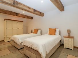 A bedroom with twin beds and a wardrobe at Two Parks Barn Upton Bishop near Ross-On-Wye