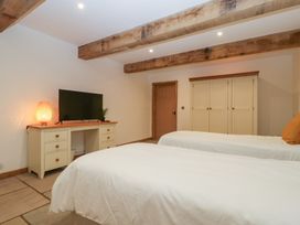 A bedroom with two beds and a television in Two Parks Barn near Upton Bishop