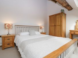 A bedroom with a bed and wooden furniture at Two Parks Barn Upton Bishop near Ross-On-Wye