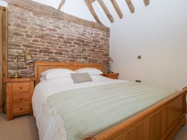 A bedroom with a bed and bedside table at Two Parks Barn near Ross-On-Wye