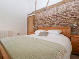 A bedroom with a bed and side table at Two Parks Barn Upton Bishop near Ross-On-Wye