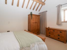 A bedroom with a bed and wooden furniture at Two Parks Barn Upton Bishop near Ross-On-Wye