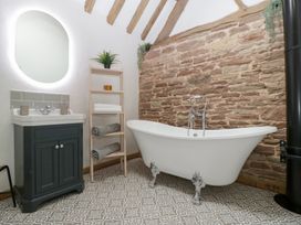 A bathroom featuring a bathtub and sink at Two Parks Barn Upton Bishop near Ross-On-Wye