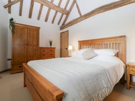 A bedroom with wooden furniture and a bed at Two Parks Barn Upton Bishop near Ross-On-Wye