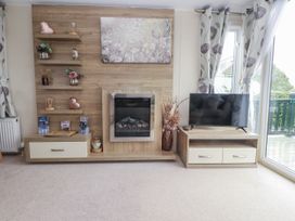 A living room with a fireplace and television at Bryncrin in Edern