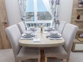 A dining room with a table set for four at Bryncrin Edern