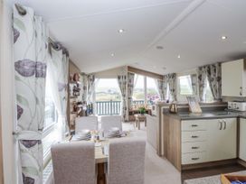 A living room with view windows and kitchen features at Bryncrin Edern