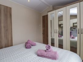 A bedroom with a bed and towels on it at Bryncrin in Edern