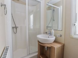 A bathroom with a shower and a hand sink at Bryncrin in Edern