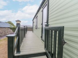 A mobile home with a deck and banister at Bryncrin Edern