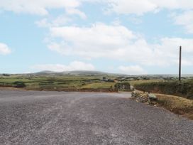 A view of a gravel driveway leading to fields and mountains at Bryncrin in Edern