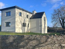 A house with windows and a stone wall at Knocknanuss in 