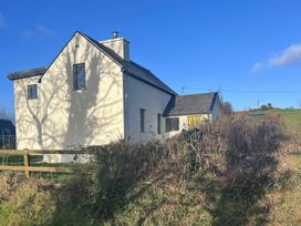 A house with windows and a roof in a field at Knocknanuss