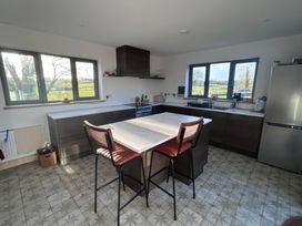 A kitchen with a kitchen island and stools at Knocknanuss