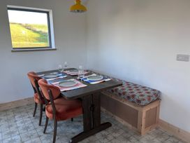 A dining room with a table and chairs at Knocknanuss