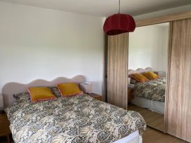 A bedroom with a bed and a mirror wardrobe at Knocknanuss in 