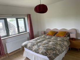 A bedroom with a bed and two windows at Knocknanuss