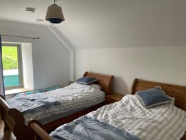 A bedroom with two beds and a window at Knocknanuss