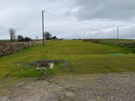 An outdoor area with a grassy field and a water source at Knocknanuss