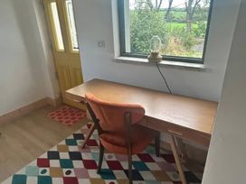 A desk with a chair and lamp in a study at Knocknanuss in Ballinascarty, County Cork