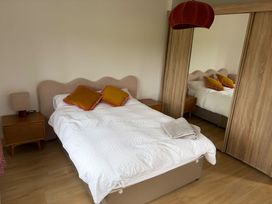 A bedroom with a bed and bedside lamp at Knocknanuss, Ballinascarty, County Cork