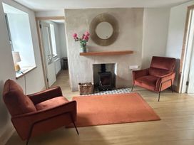 A living room with chairs and a fireplace at Knocknanuss in Ballinascarty, County Cork