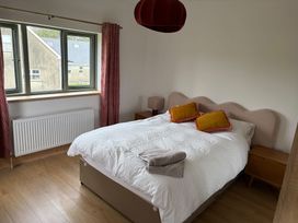 A bedroom with a bed and window at Knocknanuss, Ballinascarty, County Cork