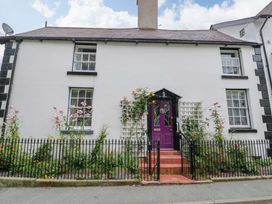 A house with a purple door and flowers in the garden at Bryn Dwr in Llangollen