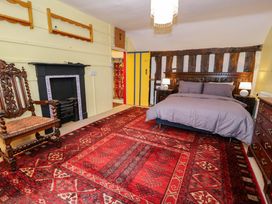 A bedroom with a bed and armchair at Bryn Dwr in Llangollen