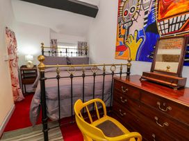 A bedroom with a bed, dresser and artwork at Bryn Dwr, Llangollen