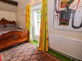 A bedroom with a wooden bed and window in Bryn Dwr, Llangollen