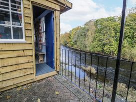 A wooden cabin with a view of a river at Bryn Dwr in Llangollen