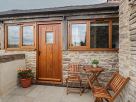 An outdoor area with wooden furniture and a flower pot at The Old Cart Shed in Gorsley