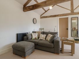 A living room with a sofa and side table at The Old Cart Shed in Gorsley
