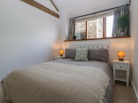 A bedroom with a bed and bedside tables at The Old Cart Shed in Gorsley