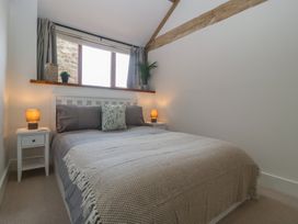 A bedroom with a bed and nightstands at The Old Cart Shed in Gorsley