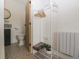 A bathroom with a toilet, sink, and clothes rack at The Old Cart Shed in Gorsley