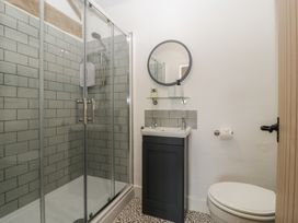 A bathroom with a shower, toilet, and sink at The Old Cart Shed in Gorsley