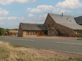 An exterior view of a building with a tractor and gate at The Old Cart Shed in Gorsley