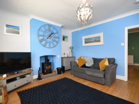 A living room with a television and a grey sofa at Seahorse in Filey